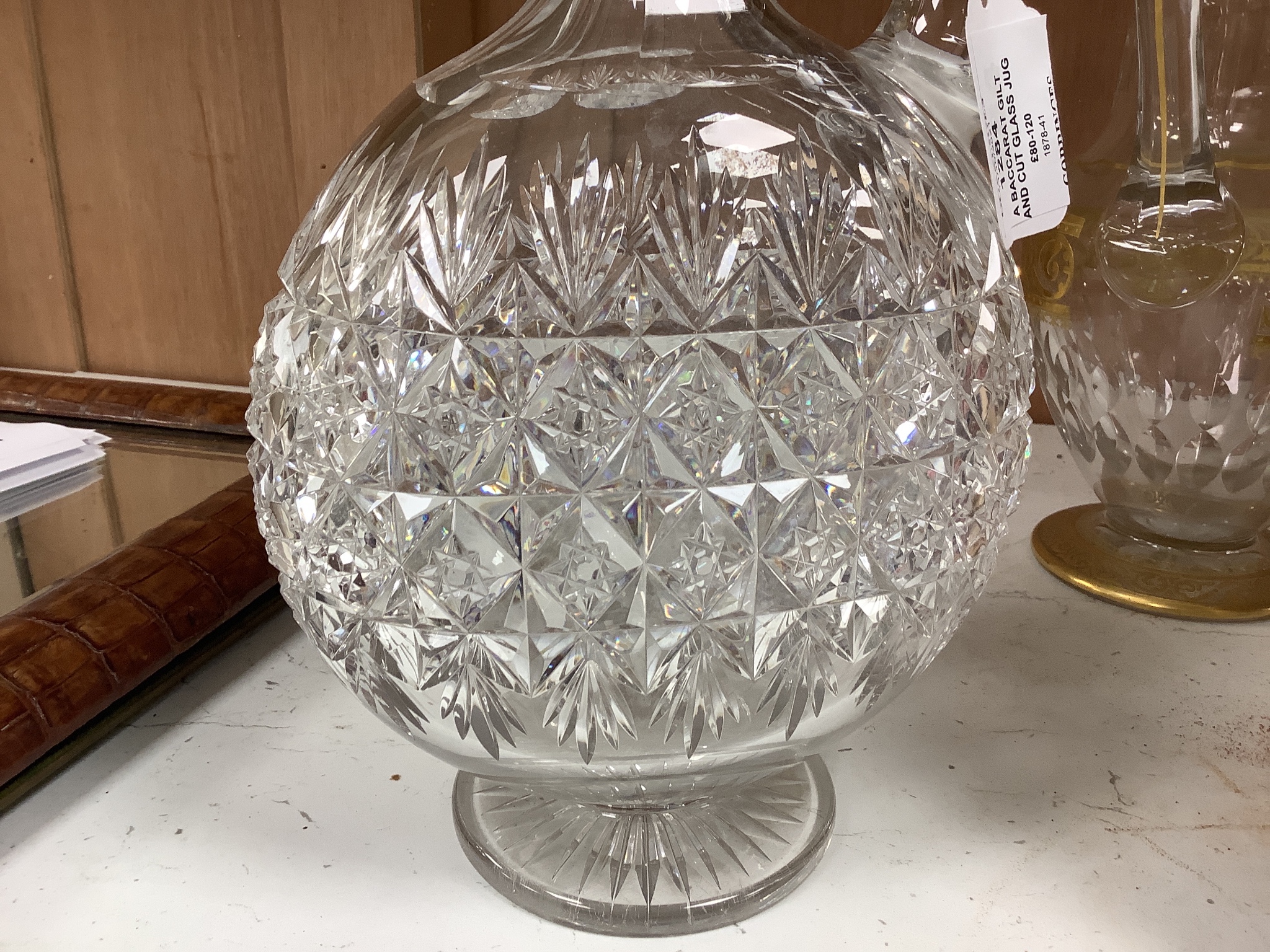 A Baccarat gilt and cut glass jug and a strawberry cut glass decanter and stopper, tallest 38 cm